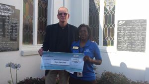 Fr Jim awarding the scholarship check to Tracy Jones, Director of the Boy's and Girls Club, Lake and Sumpter Counties; South Lake Unit.